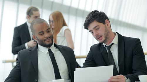 Business Professionals Discuss Documents in Modern Office