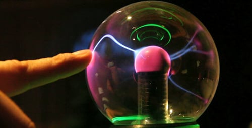 Finger Touching Bright Plasma Ball in Dark Setting