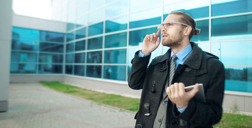 Man Using Tablet and Smart Glasses Outside