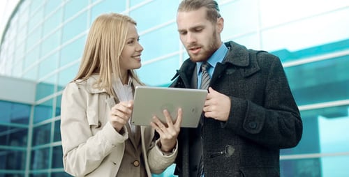 Business Colleagues Discussing Tablet Outside Office Building