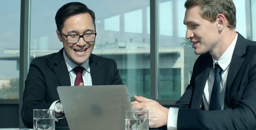 Businessmen Collaborating and Celebrating Success in Modern Office
