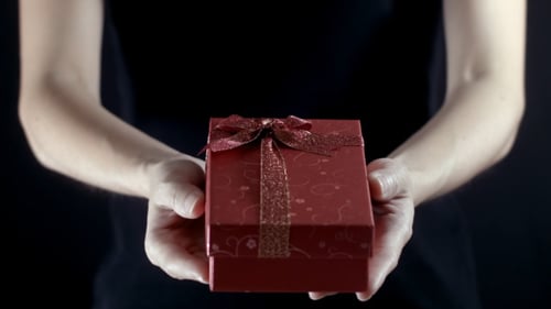 Hands Presenting Red Gift Box Close Up