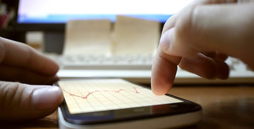 Hands Scrolling Charts on Mobile Phone