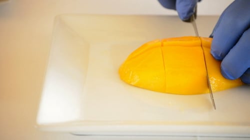 Cutting Fresh Mango on White Plate