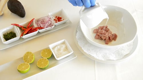 Gloved Person Preparing Fresh Ceviche in a Kitchen