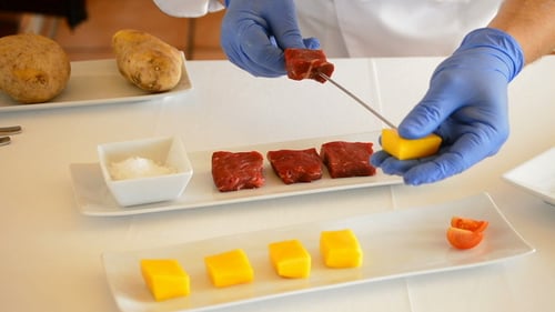 Chef Preparing food skewers with mango and meat