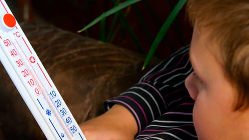 Child Holds Thermometer Showing Below Zero Temperature
