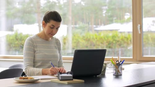 Young Woman with Laptop Working at Home Office