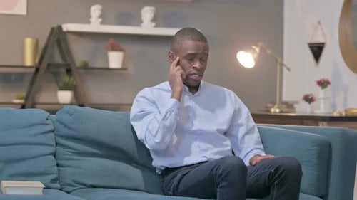 Man with a headache rubbing his head