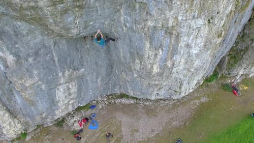 Aerial view of a man rock climbing up a mountain