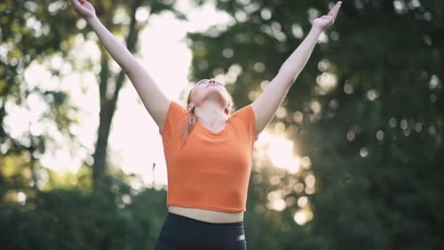 Woman Practicing Yoga in a Leafy Park