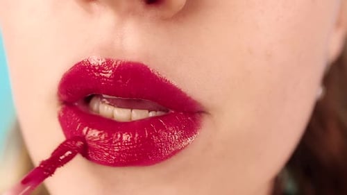 Woman Applies Vivid Red Lip Gloss
