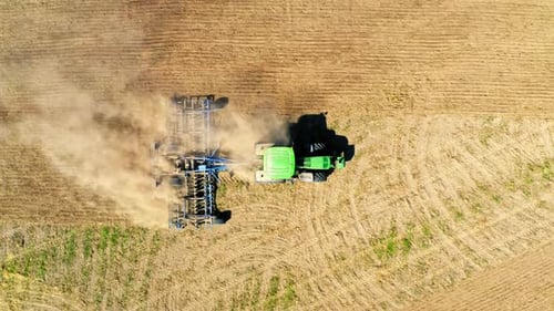 Top view of tractor plowing a field, view from drone