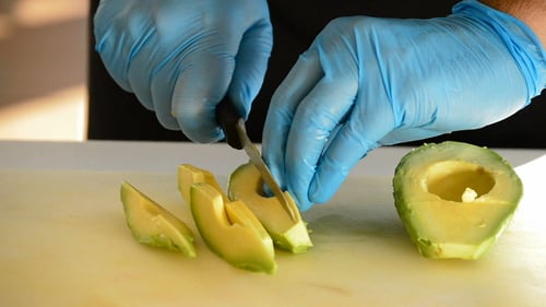 Avocado Being Sliced on a Cutting Board
