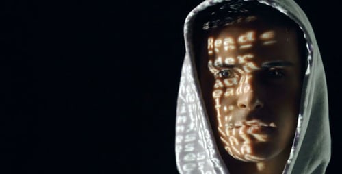 Young Adult Face Lit by Projected Computer Code