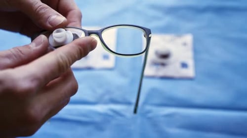 Hands Inserting Lenses into Glasses Frames