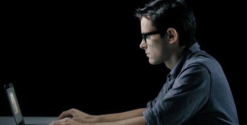 Young Adult Typing on Laptop at Desk