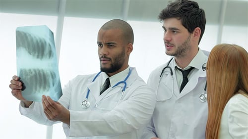 Doctors Discussing X-Ray and Tablet Results in Office