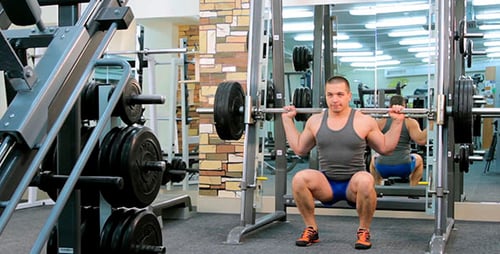 Man Doing Squats at the Gym