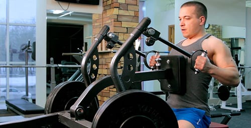 Muscular Man Doing Seated Cable Rows in Gym