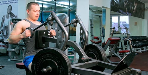 Man Working Out on Weight Machine at Gym