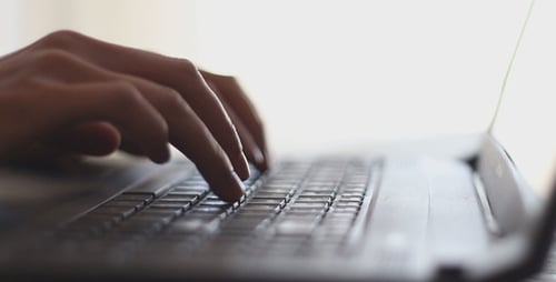 Hands Typing on Laptop Keyboard in Close-Up
