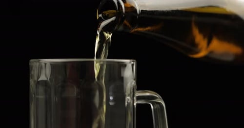 Pouring Cold Light Beer From Bottle Into a Glass. Craft Beer Close-up