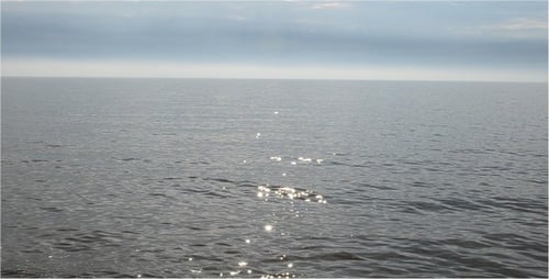 Still Blue Ocean Water on a Cloudy Day