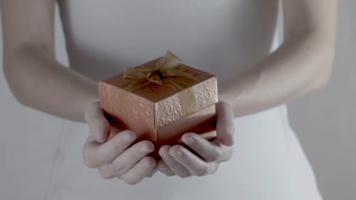 Woman Holding a Small Wrapped Gift