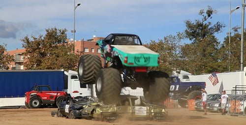Monster Truck Driving over Crushed Car