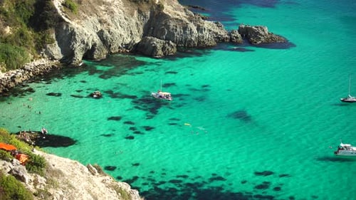 Boats and Yachts in the Rocky Bay with Crystal Clear Azure Sea on a Sunny Day