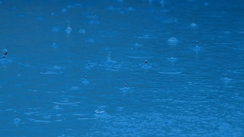 Regen auf blauem Poolwasser