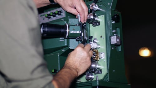 Film Technician Mounting 16mm Film Projector