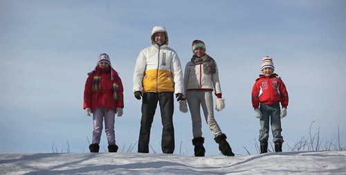 Family in Snow Smiling Together in Winter Landscape