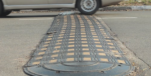 Cars Traverse Speed Bump on City Road