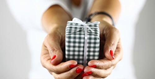 Hands Presenting Small Gift with Red Nails