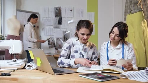 Fashion Designers Collaborating at a Wooden Table