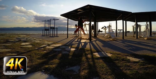 People Exercising at Waterfront Fitness Park at Sunset