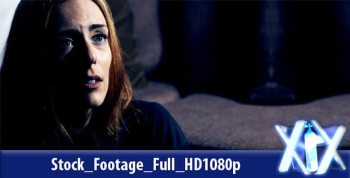 Distraught Woman Covers Face in Dimly Lit Room