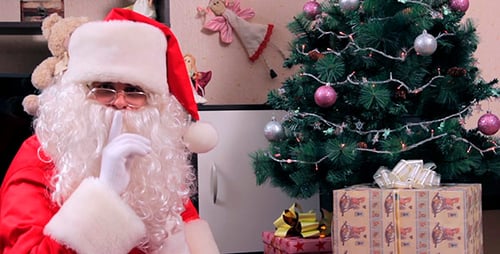 Santa Claus Placing Gifts Under Christmas Tree