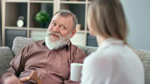 Friendly Senior Man Talking to a Woman on Couch