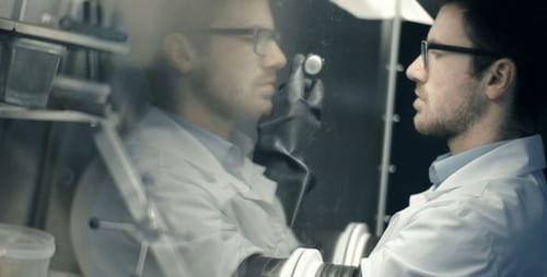 Scientist Using Isolation Chamber for Experiment