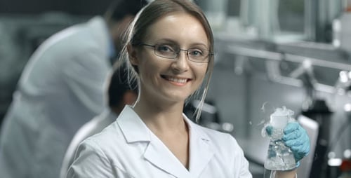 Woman Scientist Holding Steaming Flask in Lab