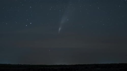 Comet Streaks Across Night Sky with Shimmering Stars