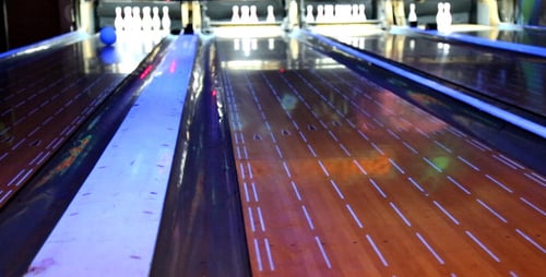Colorful Bowling Balls Rolling Down Lanes in Bowling Alley