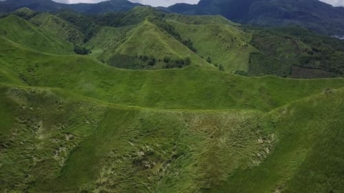 Flight over Green Grassy Rocky Hills