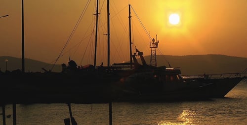 Boats Silhouetted at Golden Sunrise on Water