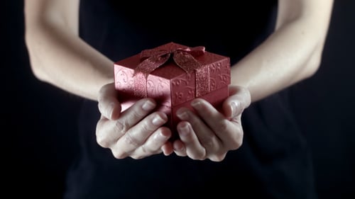 Hands Presenting Small Red Gift Box