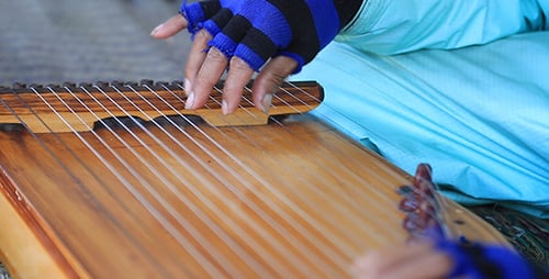 Person Playing a Wooden String Instrument