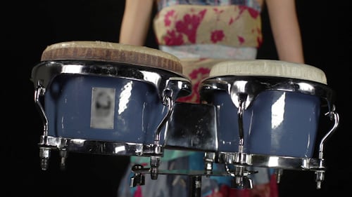 Girl Playing Bongo Drums on Black Background